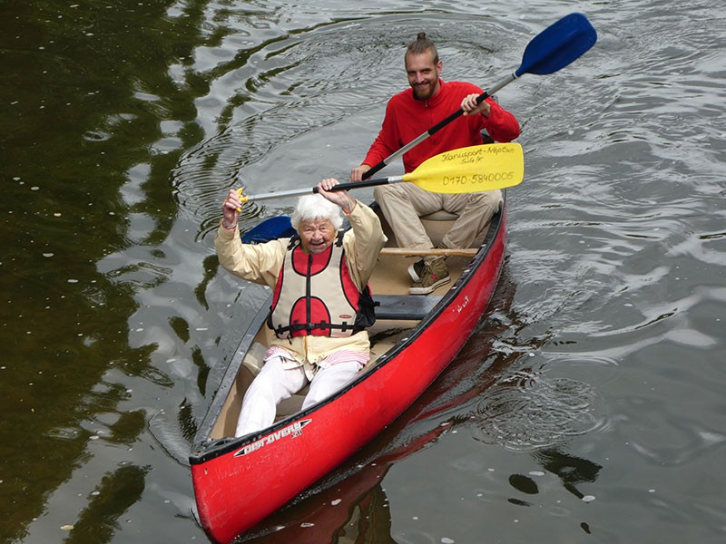 Oma Else mit 95 auf Tour in rotem Kanu vorne sitzend